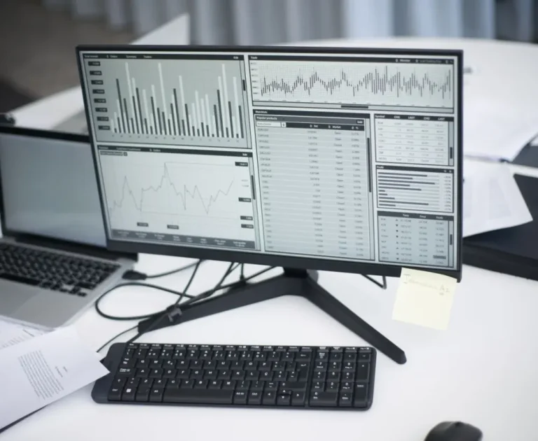 Monitors showing performance dashboards and charts on a desk